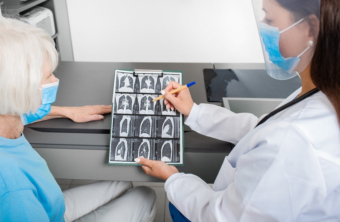A doctor is looking at an x-ray of a patient.