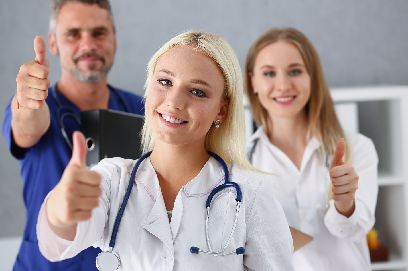 Quality Three doctors are smiling and giving thumbs up.